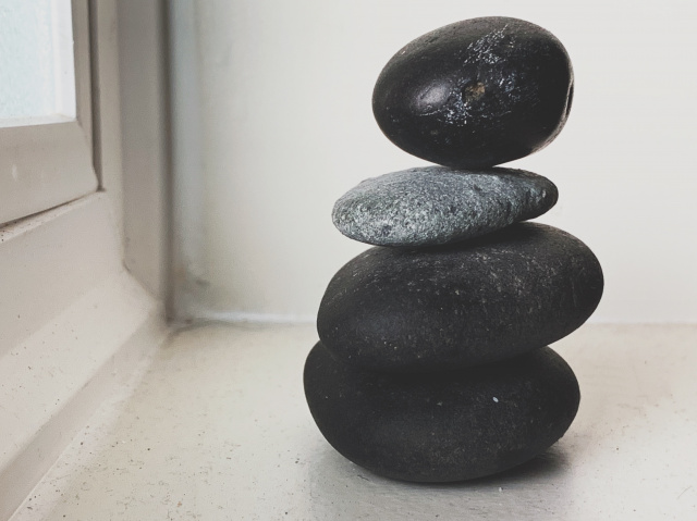 photo of four rocks stacked in a windowsill